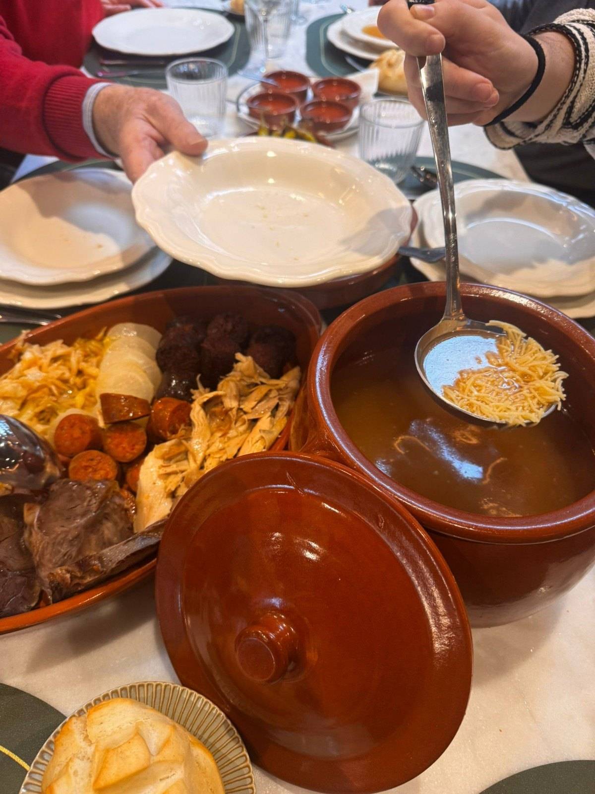 Comensales sirviéndose el caldo del cocido madrileño
