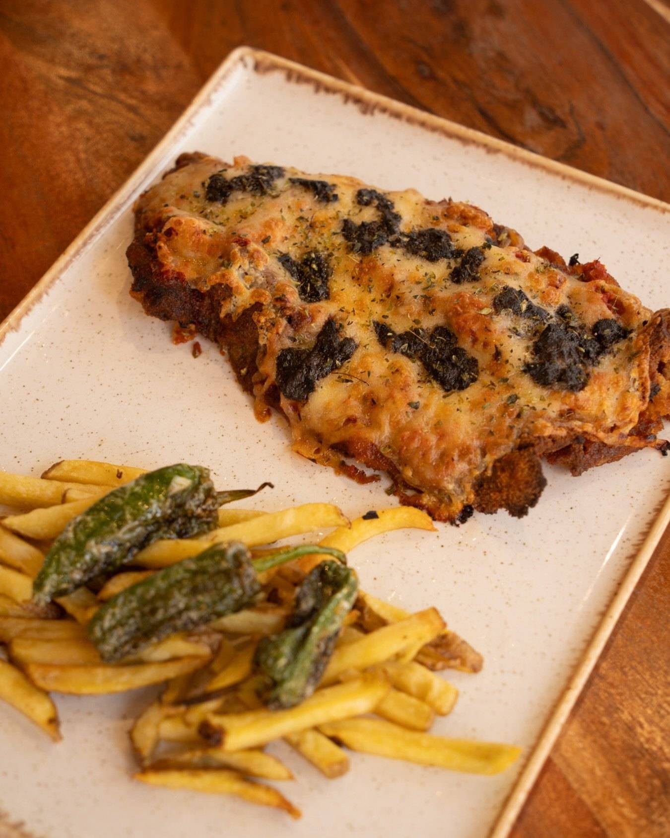 Milanesa trufada con patatas y pimientos fritos