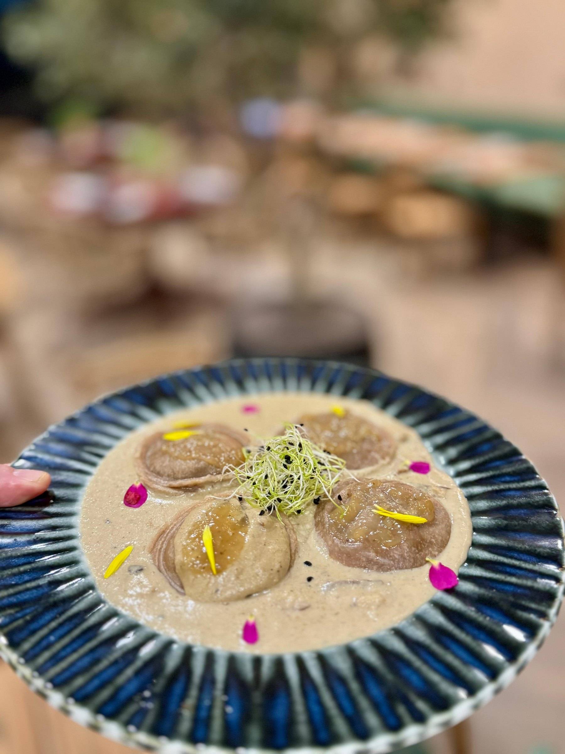 Sorrentinos rellenos en crema de boletus con brotes y flores